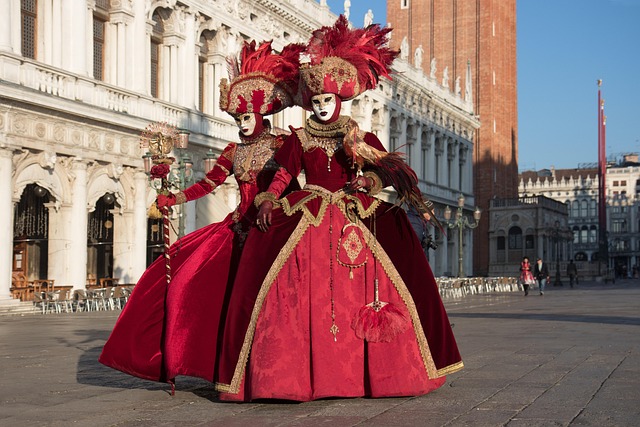 Deux personnages masqués en costumes prennent la pose sur la Place Saint-Marc au Carnaval de Venise