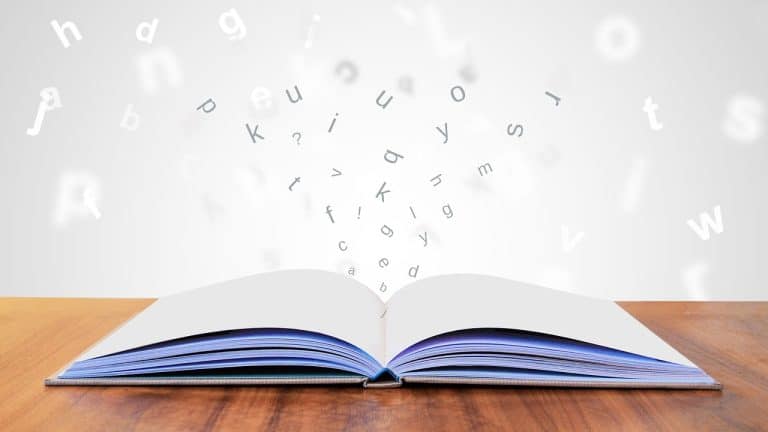 Un livre de grammaire ouvert d'où s'échappent des lettres de l'alphabet, illustrant une méthode pour apprendre l'italien avec plaisir au quotidien.