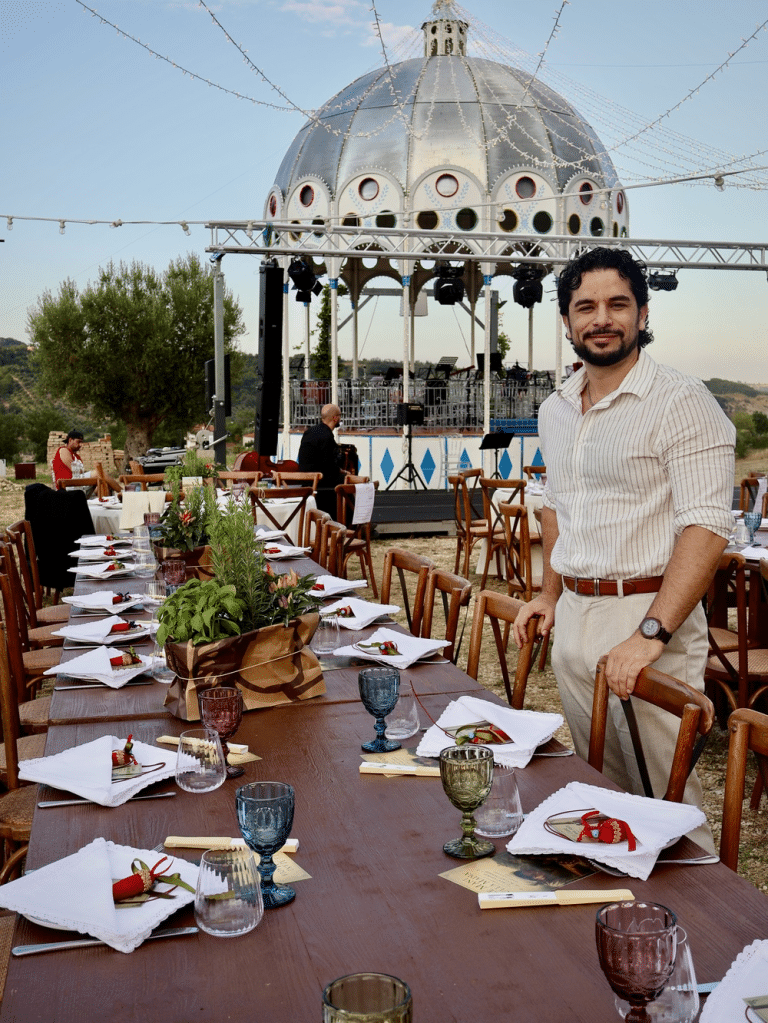 Vale' de Casa Bandera devant une table dressée pour un repas a l'italienne